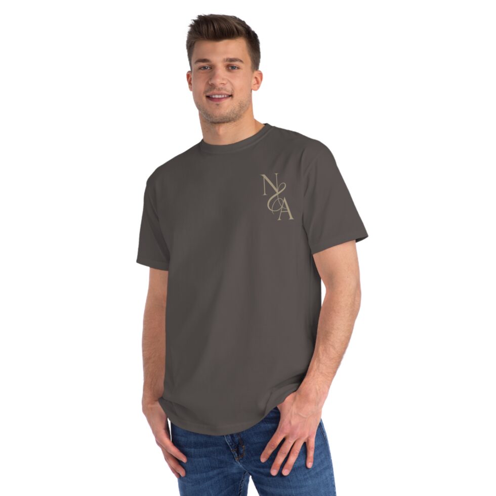 A photo of a male white model wearing a charcoal color tee shirt with a gold design NA tee shirt design.