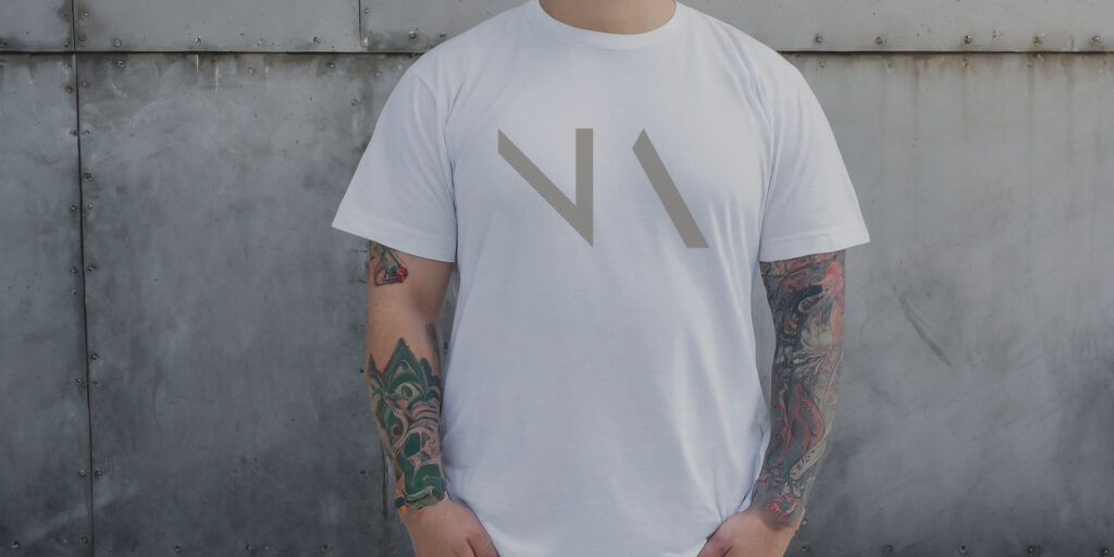 Cropped photo of a young man wearing a white NA tee shirt.