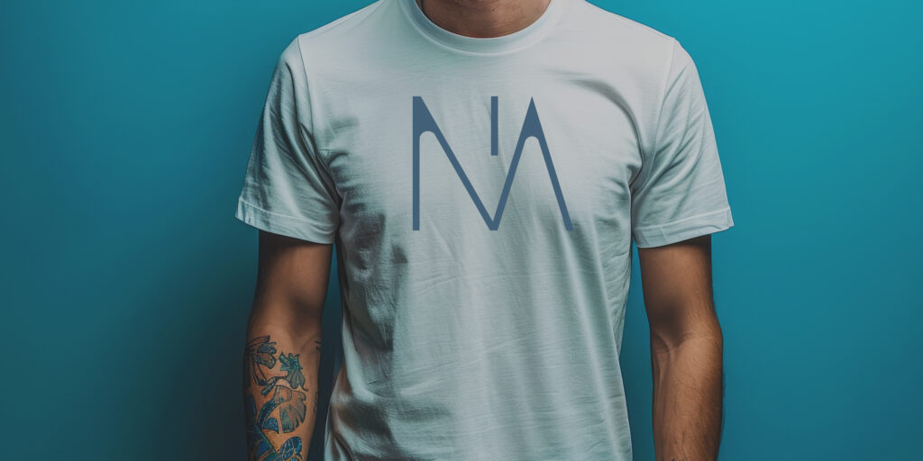 Cropped photo of a young man with tattoos wearing a white NA tee shirt.