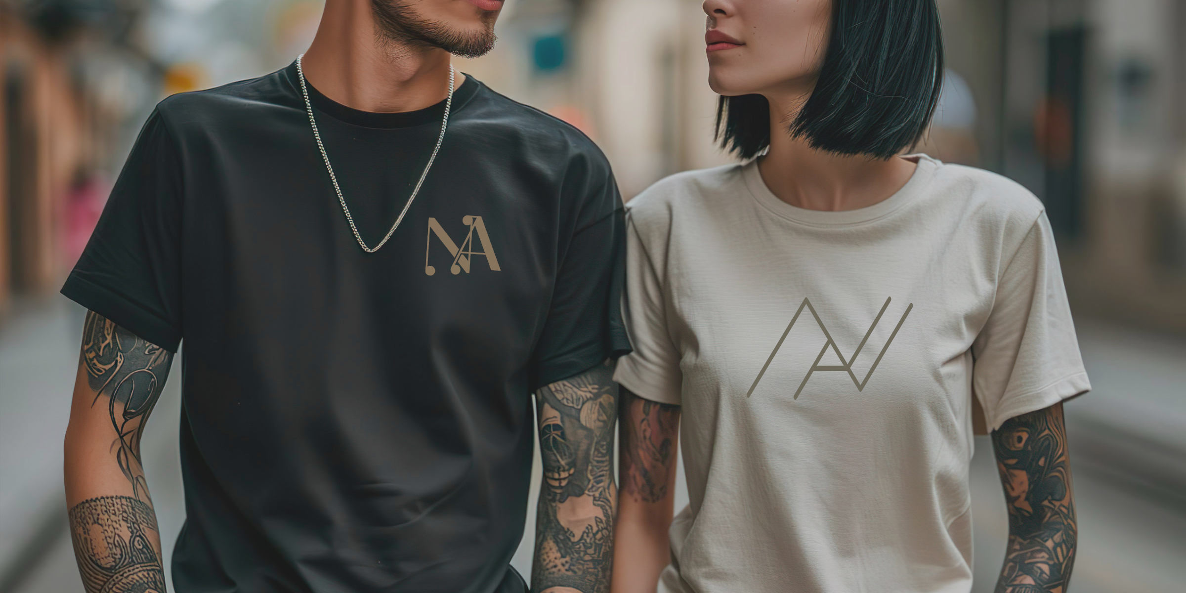 Cropped photo of a couple with tattoos wearing NA Tee Shirts.